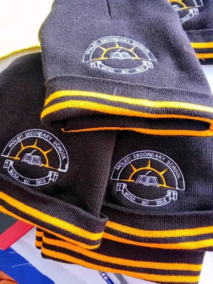 School knitwear with embroidered Molefi Secondary School crests and yellow trim.