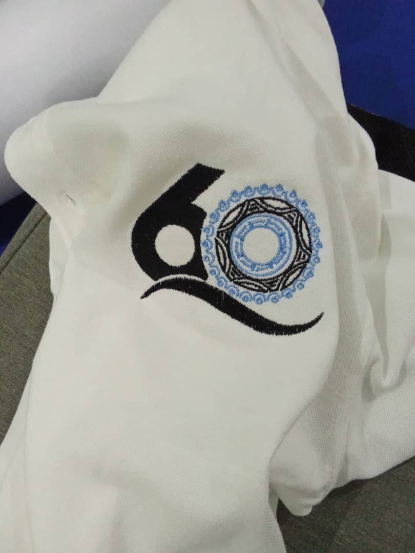 Close-up of a black and blue embroidered emblem on white fabric.