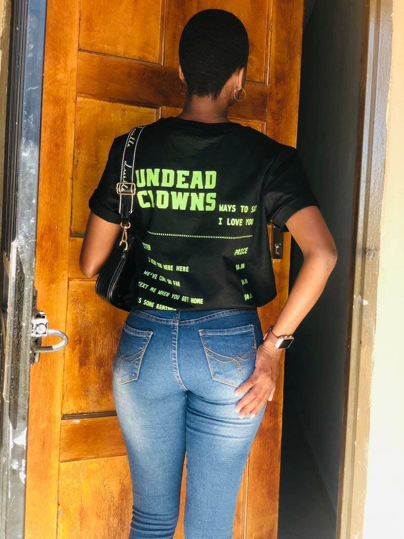Back view of a black Undead Clowns T-shirt with a large green and white graphic.